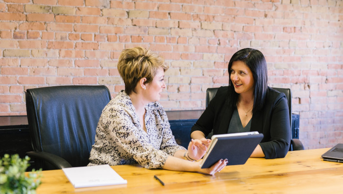 Two women meeting at desk in conference room