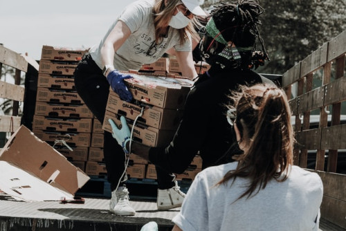 Volunteers helping move crates of food off truck